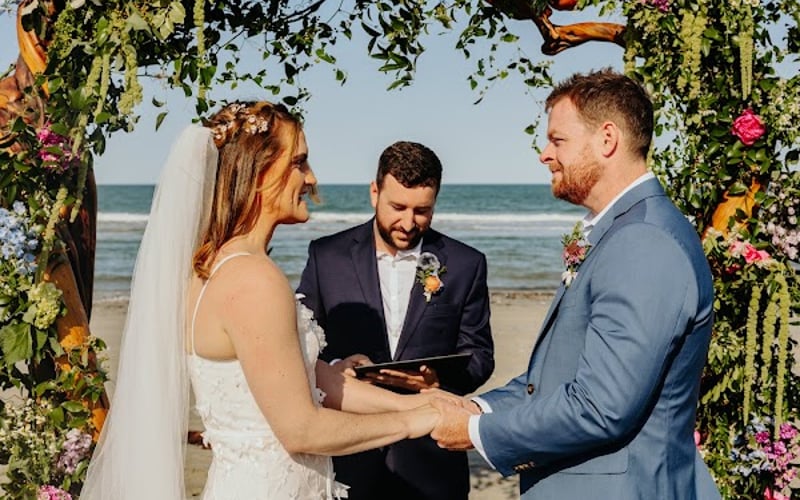 Vows at the floral arch on the beach